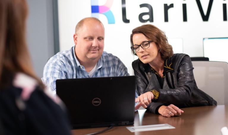 Kim and Jerry of KlariVis meeting and looking at laptop